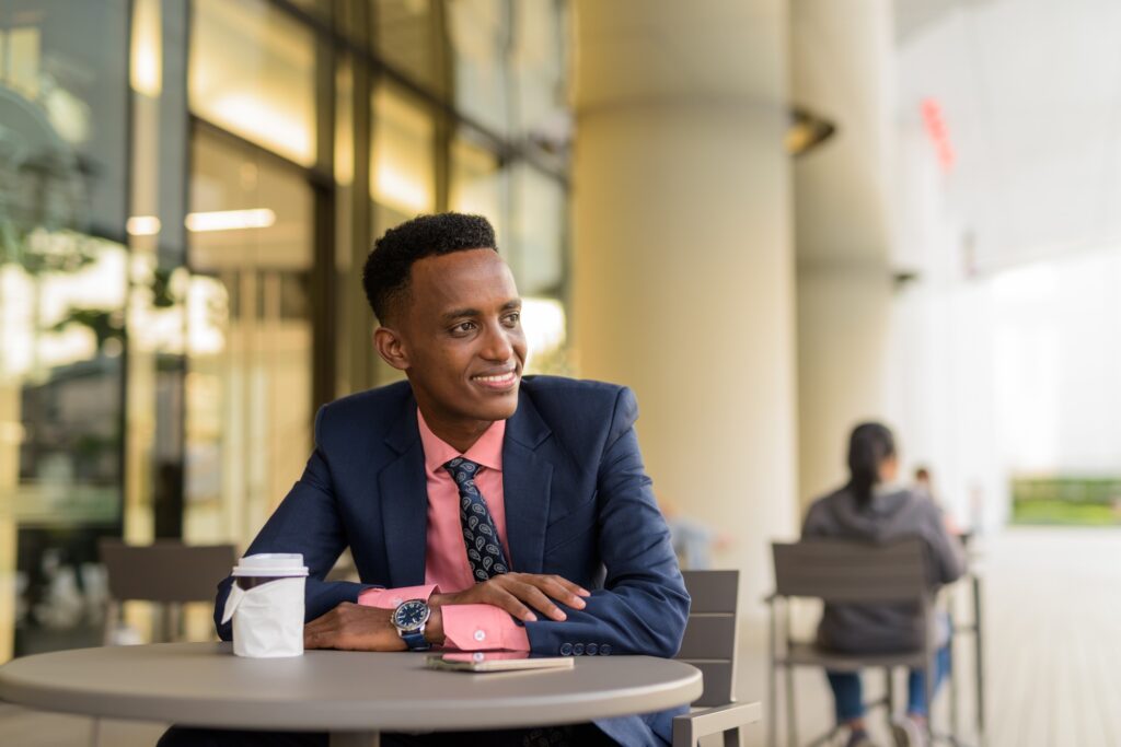 Portrait of successful young African businessman wearing suit and tie while thinking