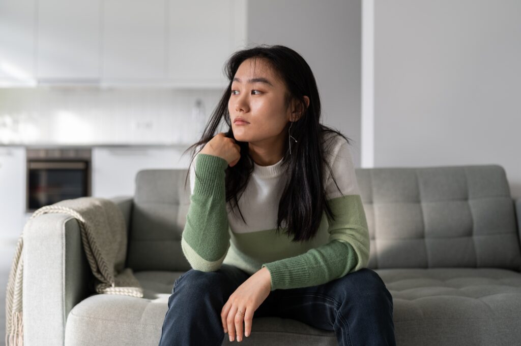 Sad lonely young Asian woman having depression symptoms worrying about money or family problems