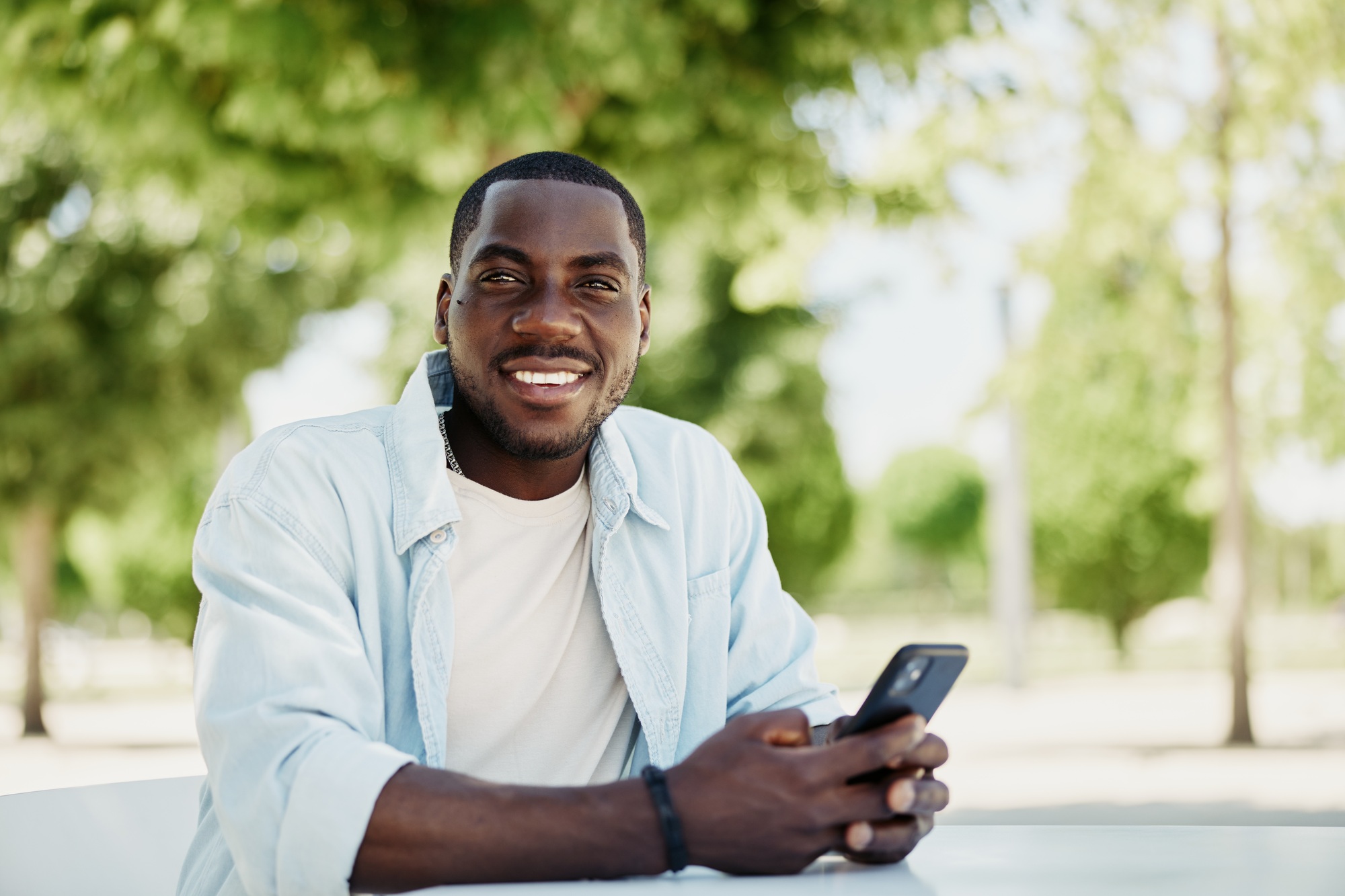 Man smile mobile cellphone smartphone phone lifestyle person black male happy looking young